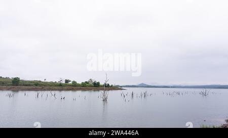 Lac dans une zone montagneuse avec verdure partiellement couverte de nuages Banque D'Images