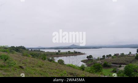 Lac dans une zone montagneuse avec verdure partiellement couverte de nuages Banque D'Images