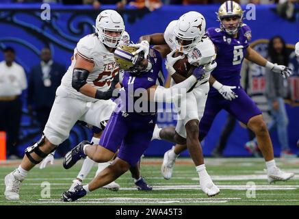 La Nouvelle-Orléans, États-Unis. 02 janvier 2024. Le running back du Texas Longhorns CJ Baxter tente de repousser Alphonzo Tuputala, le linebacker des Huskies de Washington, au premier quart-temps du Caesars Superdome à la Nouvelle-Orléans, en Louisiane, le lundi 1 janvier 2024. Photo AJ Sisco/UPI crédit : UPI/Alamy Live News Banque D'Images