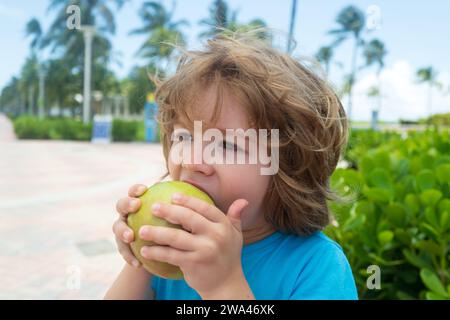 Enfant Apple. Kid habillé tenue décontractée et pomme et montrant mange des aliments sains. Banque D'Images