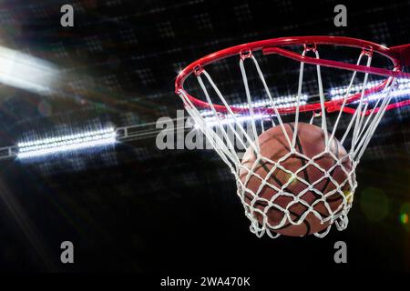 Un gros plan d'un ballon de basket tombant à travers le filet pour marquer des points Banque D'Images