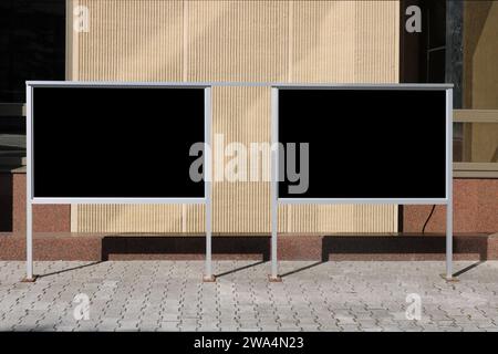 Panneaux publicitaires avec surface isolée noire près du bâtiment administratif Banque D'Images