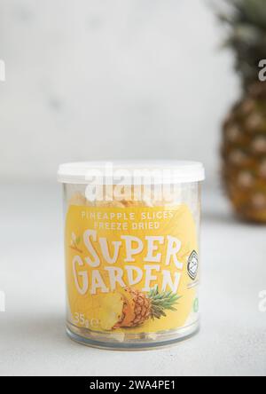 LONDRES, Royaume-Uni - 14 NOVEMBRE 2023 : pot en plastique de Super Garden Freeze tranches d'ananas séchées sur table lumineuse. Banque D'Images