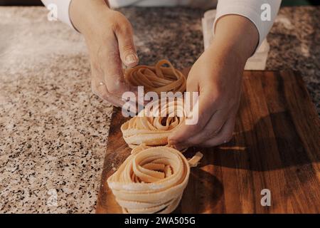 Faites de la culture à la maison en préparant des pâtes de tagliatelle roulées faites maison Banque D'Images