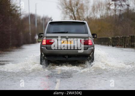 Allerton Bywater, Castleford, Royaume-Uni. 02 janvier 2024. Une voiture traverse la route inondée causée par les tempêtes et les fortes pluies sur l'A656 près de Leeds à Barnsdale Road A656, Allerton Bywater, Castleford, Royaume-Uni, le 2 janvier 2024 (photo de James Heaton/News Images) à Allerton Bywater, Castleford, Royaume-Uni le 1/2/2024. (Photo de James Heaton/News Images/Sipa USA) crédit : SIPA USA/Alamy Live News Banque D'Images