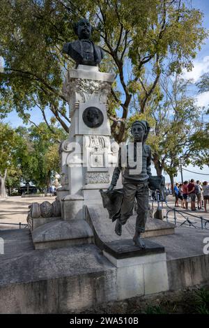 Le garçon de journal devant le Monument à Eduardo Coelho, fondateur, en 1864, et éditeur du journal populaire Diario de Noticias, à Sao Pedr Banque D'Images