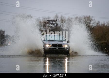 Une voiture traverse la route inondée causée par les tempêtes et les fortes pluies sur l’A656 près de Leeds à Barnsdale Road A656, Allerton Bywater, Castleford, Royaume-Uni, 2 janvier 2024 (photo de James Heaton/News Images) Banque D'Images