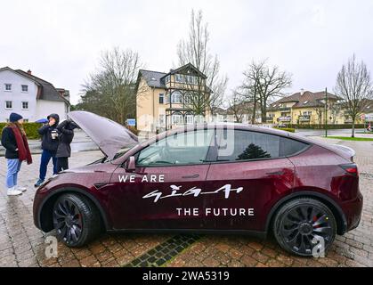 02 janvier 2024, Brandenburg, Grünheide : un véhicule électrique Tesla Model y se tient sous la pluie lors de l'événement d'information «Road Show» organisé par le constructeur de voitures électriques américain Tesla sur la place du marché. Le constructeur de voitures électriques américain Tesla organise un Road show pour promouvoir l’expansion prévue de son site d’usine. La série de cinq événements d'information pour les résidents locaux a commencé mardi à Grünheide dans le Brandebourg. L'usine automobile est située dans la municipalité. Tesla veut construire un dépôt de fret, des entrepôts et une garderie sur un site adjacent. Photo : Patrick Pleul/dpa Banque D'Images