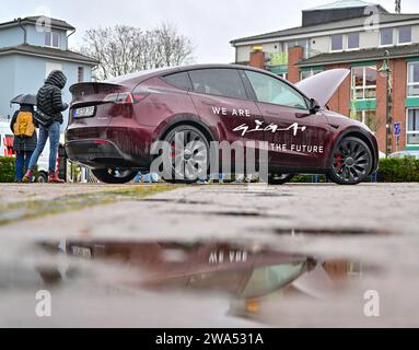 02 janvier 2024, Brandenburg, Grünheide : un véhicule électrique Tesla Model y se tient sous la pluie lors de l'événement d'information «Road Show» organisé par le constructeur de voitures électriques américain Tesla sur la place du marché. Le constructeur de voitures électriques américain Tesla organise un Road show pour promouvoir l’expansion prévue de son site d’usine. La série de cinq événements d'information pour les résidents locaux a commencé mardi à Grünheide dans le Brandebourg. L'usine automobile est située dans la municipalité. Tesla veut construire un dépôt de fret, des entrepôts et une garderie sur un site adjacent. Photo : Patrick Pleul/dpa Banque D'Images