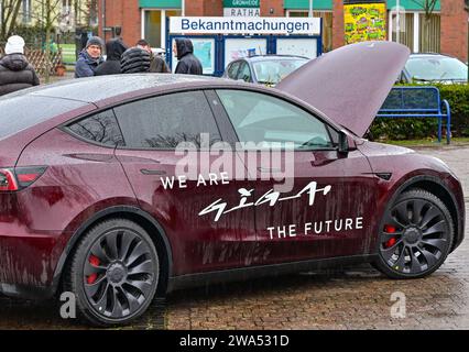 02 janvier 2024, Brandenburg, Grünheide : un véhicule électrique Tesla Model y se tient sous la pluie lors de l'événement d'information «Road Show» organisé par le constructeur de voitures électriques américain Tesla sur la place du marché. Le constructeur de voitures électriques américain Tesla organise un Road show pour promouvoir l’expansion prévue de son site d’usine. La série de cinq événements d'information pour les résidents locaux a commencé mardi à Grünheide dans le Brandebourg. L'usine automobile est située dans la municipalité. Tesla veut construire un dépôt de fret, des entrepôts et une garderie sur un site adjacent. Photo : Patrick Pleul/dpa Banque D'Images