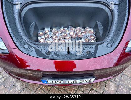 02 janvier 2024, Brandenburg, Grünheide : chocolat dans un véhicule électrique Tesla Model y debout sous la pluie lors de l'événement d'information «Road Show» organisé par le constructeur de voitures électriques américain Tesla sur la place du marché. Le constructeur de voitures électriques américain Tesla organise un Road show pour promouvoir l’expansion prévue de son site d’usine. La série de cinq événements d'information pour les résidents locaux a commencé mardi à Grünheide dans le Brandebourg. L'usine automobile est située dans la municipalité. Tesla veut construire un dépôt de fret, des entrepôts et une garderie sur un site adjacent. Photo : Patrick Pleul/ Banque D'Images