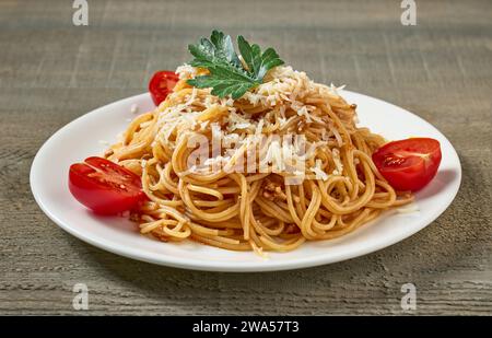 assiette de spaghetti avec sauce bolognaise et tomates sur table de cuisine en bois Banque D'Images