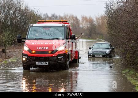 Allerton Bywater, Castleford, Royaume-Uni. 02 janvier 2024. Une camionnette de récupération d'autoroute tire une voiture coincée sur la route inondée causée par des tempêtes et de fortes pluies près de Leeds sur Newton Lane, Fairburn, Castleford, Royaume-Uni, le 2 janvier 2024 (photo de James Heaton/News Images) à Allerton Bywater, Castleford, Royaume-Uni le 1/2/2024. (Photo de James Heaton/News Images/Sipa USA) crédit : SIPA USA/Alamy Live News Banque D'Images