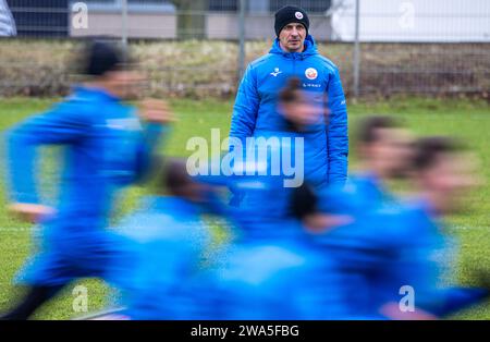 Rostock, Allemagne. 02 janvier 2024. Football : 2e Bundesliga, coup d'envoi à l'entraînement du FC Hansa Rostock. (Longue exposition) Mersad Selimbegovic, le nouvel entraîneur du FC Hansa Rostock, observe les joueurs lors de leur première séance d’entraînement en préparation de la seconde moitié de la 2e saison de Bundesliga. Le joueur de 41 ans est censé sauver l'équipe hanséatique de la relégation de la 2e division. Crédit : Jens Büttner/dpa/Alamy Live News Banque D'Images