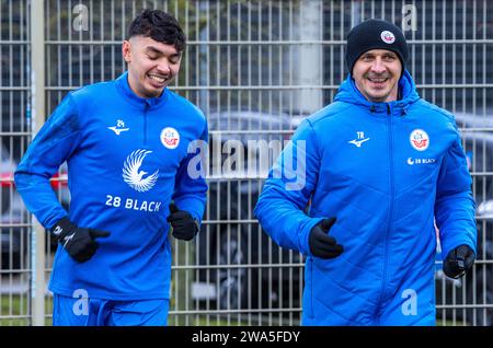 Rostock, Allemagne. 02 janvier 2024. Football : Bundesliga 2, coup d'envoi de l'entraînement pour le FC Hansa Rostock. Mersad Selimbegovic (à droite), le nouvel entraîneur du FC Hansa Rostock, traverse le terrain avec John-Patrick Strauß (à gauche) de Rostock lors de la première séance d'entraînement en préparation de la seconde moitié de la 2e Bundesliga. Le joueur de 41 ans est censé sauver l'équipe hanséatique de la relégation de la 2e division. Crédit : Jens Büttner/dpa/Alamy Live News Banque D'Images