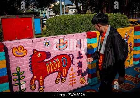 Taichung, Chine. 02 janvier 2024. Les gens interagissent avec le Street art vibrant au Rainbow Village à Taichung, Taiwan le 02/01/2024 les peintures murales colorées, créées par Huang Yung-Fu, un ancien soldat connu sous le nom de "Rainbow Grandpa", ont transformé un village dépendant de l'armée en une destination artistique célèbre, le sauver de la démolition et capturer l'esprit de la communauté avec ses peintures fantaisistes. Le village est devenu une attraction touristique populaire et sert en même temps comme un symbole significatif du patrimoine local et de la résistance créative par Wiktor Dabkowski crédit : dpa / Alamy Live News Banque D'Images