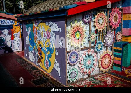 Taichung, Chine. 02 janvier 2024. Les gens interagissent avec le Street art vibrant au Rainbow Village à Taichung, Taiwan le 02/01/2024 les peintures murales colorées, créées par Huang Yung-Fu, un ancien soldat connu sous le nom de "Rainbow Grandpa", ont transformé un village dépendant de l'armée en une destination artistique célèbre, le sauver de la démolition et capturer l'esprit de la communauté avec ses peintures fantaisistes. Le village est devenu une attraction touristique populaire et sert en même temps comme un symbole significatif du patrimoine local et de la résistance créative par Wiktor Dabkowski crédit : dpa / Alamy Live News Banque D'Images