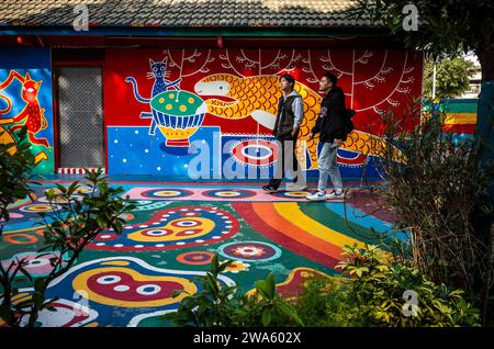 Taichung, Chine. 02 janvier 2024. Les gens interagissent avec le Street art vibrant au Rainbow Village à Taichung, Taiwan le 02/01/2024 les peintures murales colorées, créées par Huang Yung-Fu, un ancien soldat connu sous le nom de "Rainbow Grandpa", ont transformé un village dépendant de l'armée en une destination artistique célèbre, le sauver de la démolition et capturer l'esprit de la communauté avec ses peintures fantaisistes. Le village est devenu une attraction touristique populaire et sert en même temps comme un symbole significatif du patrimoine local et de la résistance créative par Wiktor Dabkowski crédit : dpa / Alamy Live News Banque D'Images