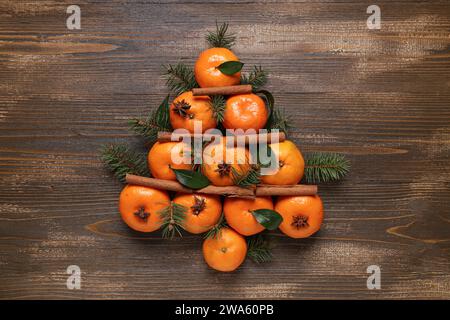Arbre de Noël fabriqué à partir de savoureuses mandarines, branches de sapin et cannelle sur une table en bois Banque D'Images