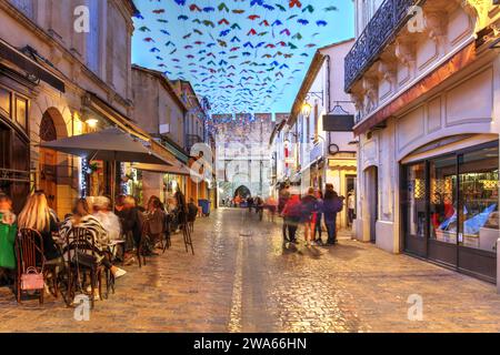 Rue piétonne dans les murs d'Aigues-mortes, cité médiévale fortifiée de Camargue, Occitanie, sud de la France au coucher du soleil. Banque D'Images