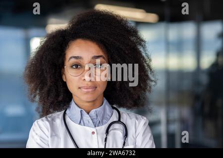 Portrait en gros plan d'une femme afro-américaine médecin, étudiante, infirmière debout dans un bureau d'hôpital, regardant avec confiance et sérieux la caméra. Banque D'Images