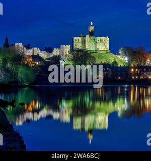 Vue au crépuscule du château de Warkworth et du village de Warkworth reflété dans la rivière Coquet comme vu de Amble avec le château de Warkworth inondé. Banque D'Images