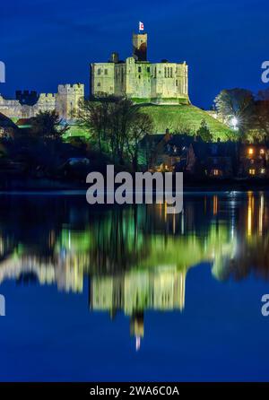 Vue au crépuscule du château de Warkworth et du village de Warkworth reflété dans la rivière Coquet comme vu de Amble avec le château de Warkworth inondé. Banque D'Images