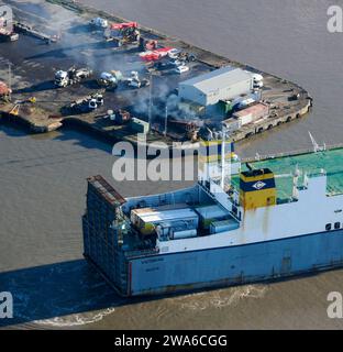 Un porte-conteneurs au départ de Seaforth Docks, Liverpool, River Mersey, Merseyside, nord-ouest de l'Angleterre, UK, fumée polluante de l'entonnoir Banque D'Images