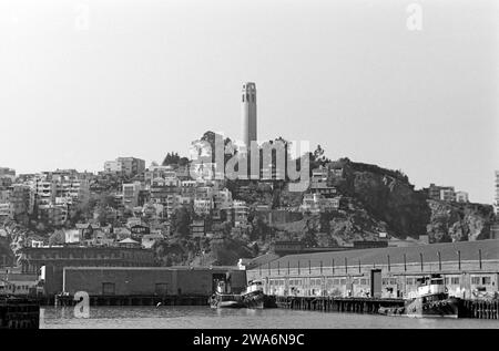 Schleppboote liegen am Kai im Hafen von San Francisco, im hintergrund der Telegraph Hill mit dem pittoresken Restaurant Julius 'Castle und dem Coit Tower, einem Aussichtsturm, der aus dem Nachlass von Lillie Hitchcock Coit zu Ehren im Dienst verstorbenem Feuerwehrpersonals errichtet wurde, San Francisco 1962. Remorqueurs amarrés au quai dans le port de San Francisco, en arrière-plan Telegraph Hill avec le pittoresque restaurant Julius 'Castle et Coit Tower, une tour d'observation construite à partir du domaine de Lillie Hitchcock Coit en l'honneur des pompiers morts dans l'exercice de leurs fonctions, San Francisco 19 Banque D'Images