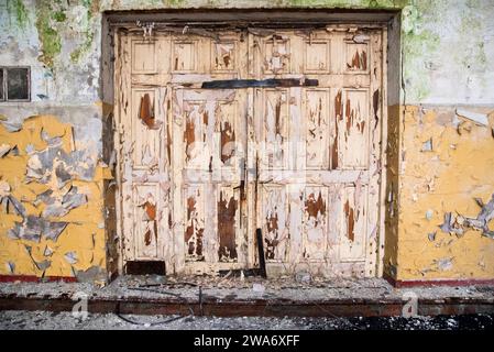 Vieille porte détruite dans une usine abandonnée. Banque D'Images