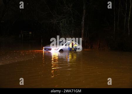 Hathern, Leicestershire, Royaume-Uni. 2 janvier 2024. Météo britannique. Un pompier vérifie l'intérieur d'une voiture échouée dans l'eau d'inondation. Des vents violents et de fortes pluies battent une grande partie du Royaume-Uni alors que la petite mais puissante tempête Henk frappe. Crédit Darren Staples/Alamy Live News. Banque D'Images