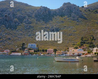 Vue sur Symi ou le port de l'île de Simi, yachts classiques, maisons sur les collines de l'île, baie de la mer Égée. Les îles de Grèce vacances voyages de vacances de l'île de Rhodos. Symi, Grèce, Dodécanèse. Banque D'Images