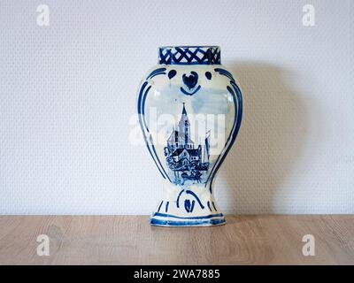 Vase en céramique bleu Delft avec une église pittoresque représentée sur une table. Le vase est en porcelaine et émaillé à l'extérieur. Banque D'Images