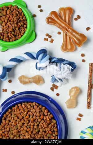 Composition avec différents aliments pour chiens et jouets sur fond clair Banque D'Images