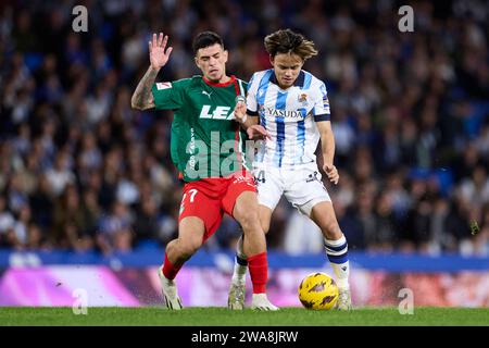 San Sebastian, Espagne. 02 janvier 2024. Takefusa Kubo de Real Sociedad est en compétition pour le ballon avec Javi Lopez de Deportivo Alaves lors du match de LaLiga EA Sports entre Real Sociedad et Deportivo Alaves au Reale Arena le 2 janvier 2024, à San Sebastian, en Espagne. Crédit : AFLO Co. Ltd./Alamy Live News Banque D'Images