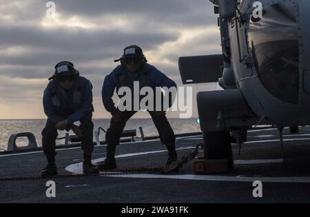 Forces militaires AMÉRICAINES. 180307KA046-0947 MER MÉDITERRANÉE (7 mars 2018) – le compagnon de Boatswain de 3e classe Daniel RiosCastillo, à gauche, et le matelot de Boatswain Jose Escobar attendent de traverser le pont d'envol après avoir placé des cales et des chaînes sur un hélicoptère MH-60S Sea Hawk, attaché aux «Ghost Riders» du Helicopter Sea Squadron (HSC) 28, pendant les quarts de vol à bord du destroyer de missiles guidés de classe Arleigh Burke USS Carney (DDG 64) en mer Méditerranée, le 7 mars 2018. Carney, déployé à l'avant à Rota, en Espagne, est à sa quatrième patrouille dans la zone d'opérations de la 6e flotte américaine à l'appui de la regiona Banque D'Images