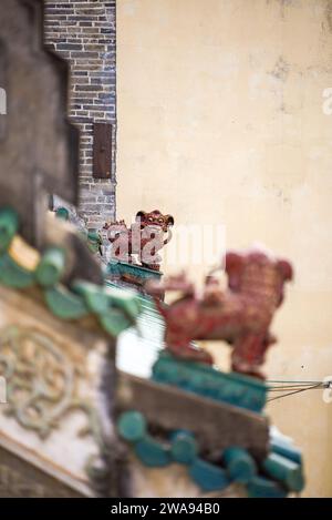 Deux lions de pierre artisanaux se regardant sur le toit d'un bâtiment classique chinois Banque D'Images