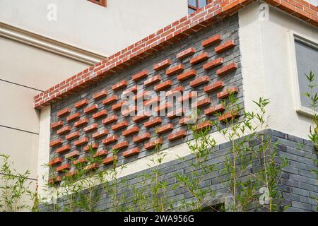 Mur décoratif en briques rouges sur un bâtiment de style traditionnel dans le quartier commercial chinois Banque D'Images