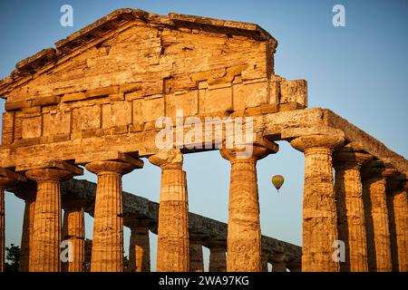 Coucher de soleil derrière les anciennes colonnes d'un temple avec un ciel clair, ambiance du soir d'été à Paestum, ancienne ville, à 35 km au sud de Salerno.Founded par les Grecs Banque D'Images