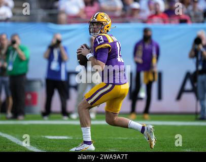 Garrett Nussmeier (13 ans), quarterback des Tigers de la LSU, tombe dans la poche en attendant de lancer la balle à un de ses joueurs ouverts lors du premier quart-temps ReliaQuest Bowl entre le Wisconsin vs LSU le lundi 1er janvier 2024 au Raymond James Stadium, Tampa, Fla. LSU bat Wisconsin 35-31 (David Venezia / image du sport) Banque D'Images