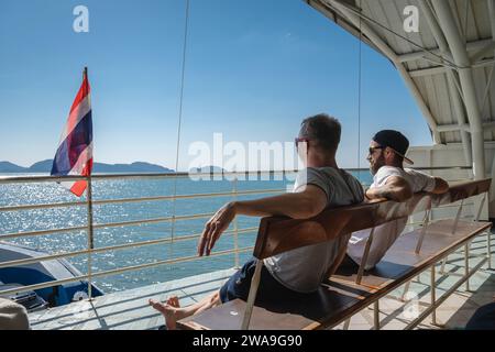 Koh Chang, Thaïlande. 28 décembre 2023. Les voyageurs sont vus assis à l'intérieur du ferry sur le chemin de l'île de Koh Chang, avec le drapeau national thaïlandais sur le pont. Le ferry pour l'île de Koh Chang part du continent Ao Thammachat Pier sur le continent pour arriver à Ao Sapparot Pier sur la côte nord-est de Koh Chang. L'île de Koh Chang, connue sous le nom d'« île des éléphants » en raison de son promontoire en forme d'éléphant, est la troisième plus grande île de Thaïlande après Phuket et Samui. (Photo Nathalie Jamois/SOPA Images/Sipa USA) crédit : SIPA USA/Alamy Live News Banque D'Images