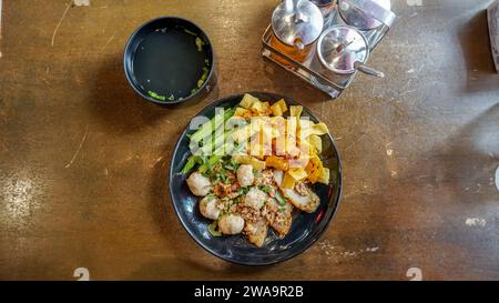 Nouilles aux œufs séchées avec wonton de porc ou boulettes de porc avec soupe de style asiatique. Nouilles de riz séchées épicées thaïlandaises avec porc, boulettes de poisson, boulettes de crevettes et Banque D'Images