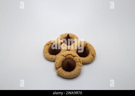 Vue rapprochée d'un petit groupe de biscuits faits maison au beurre d'arachide avec une goutte de chocolat sur le dessus, sur un fond blanc avec espace de copie Banque D'Images