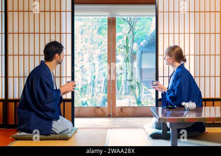 Couple caucasien buvant du thé dans une maison tipique au Japon Banque D'Images
