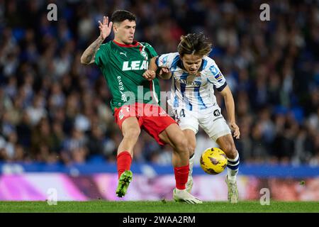 Javi Lopez de Deportivo Alaves est en compétition pour le ballon avec Takefusa Kubo de Real Sociedad lors du match de football de championnat d'Espagne de Liga entre Real Sociedad et Deportivo Alaves le 2 janvier 2024 à la Reale Arena de San Sebastian, Espagne Banque D'Images
