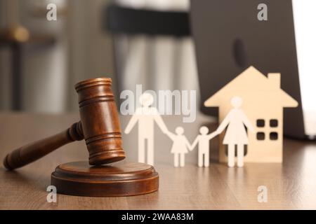 Concept de loi. Marteau, figures de parents avec enfants et maison sur table en bois, closeup Banque D'Images