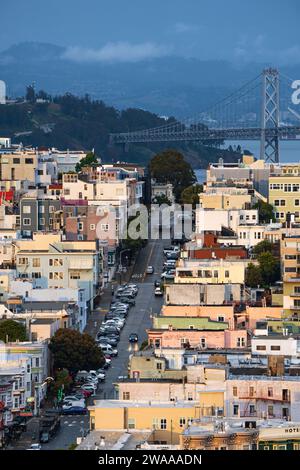 Maisons colorées de San Francisco rampant sur la colline après une tempête de pluie au printemps, USA. Nuages sombres en arrière-plan. Banque D'Images