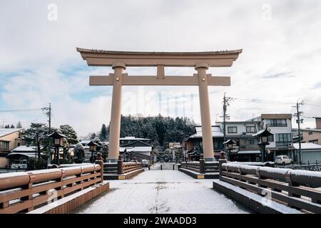 Takayama, Gifu, Japon - 18 décembre 2023 : Sakurayama Hachimangu Shrine porte Torii avec neige hivernale Banque D'Images