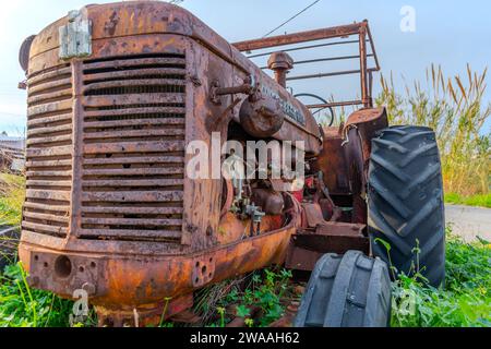 Vieux tracteur rouillé dans les champs ruraux, machines agricoles abandonnées. Banque D'Images