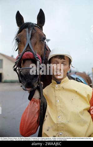 Olle Elfstrand. Entraîneur de trot suédois et jockey. Au cours de sa carrière, il a réussi l'exploit de remporter plus de 2000 courses en tant que jockey. Ici dans le sulky avec le cheval de Trotting Lyon qu'il a entraîné pendant la majeure partie de sa carrière de coureur. Lyon a été sélectionné comme cheval de l'année à trois reprises et est devenu le premier cheval de trot d'origine suédoise à atteindre un million de couronnes suédoises en prix. 1972 réf. BV9 Banque D'Images